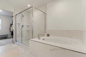 Full bathroom featuring a garden tub, a shower stall, a spacious closet, recessed lighting, and tile patterned flooring