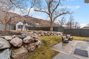 Fenced backyard with a patio area and a mountain view