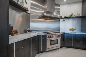 Kitchen featuring extractor fan, luxury range, dark cabinets, and modern cabinets