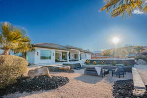 Rear view of property with a patio area, outdoor seating, a tile roof, and stucco siding
