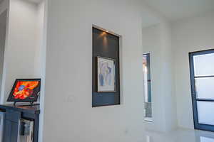 Hallway featuring light tile patterned floors and baseboards