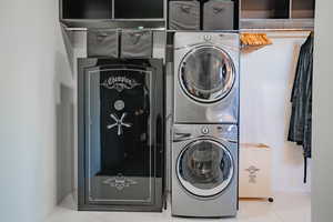 Laundry room featuring stacked washer and clothes dryer and tile patterned floors