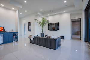 Living area featuring recessed lighting, light tile patterned flooring, wine cooler, and a dry bar