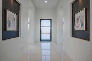 Hall with light tile patterned floors and baseboards
