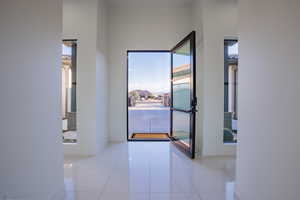 Hallway with light tile patterned flooring and baseboards