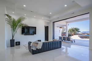 Tiled living room featuring a raised ceiling and recessed lighting