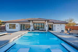 Rear view of property featuring a patio area, stucco siding, and a tiled roof