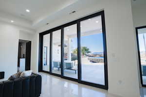 Doorway to outside featuring recessed lighting, healthy amount of natural light, tile patterned flooring, and a mountain view