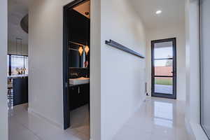 Hallway with light tile patterned floors, plenty of natural light, and recessed lighting