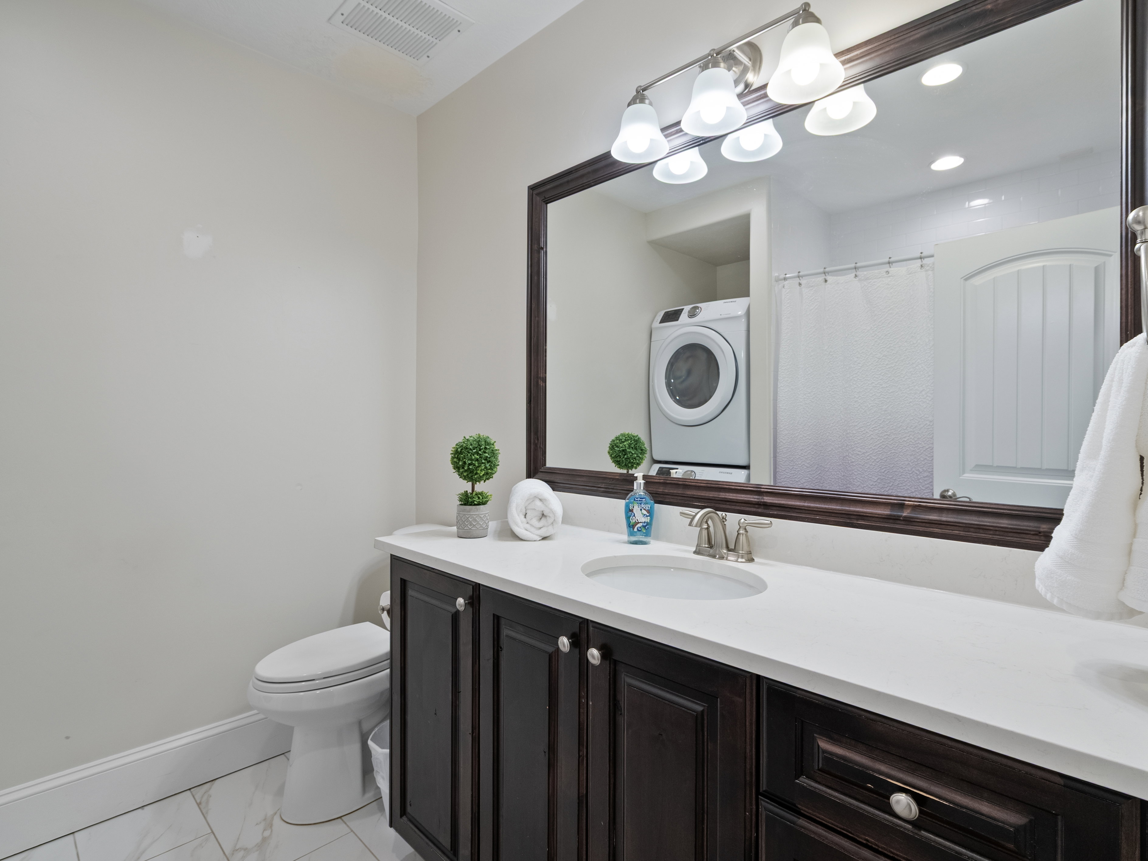 Apartment Bathroom featuring a dark wood-finish vanity with a white countertop and undermount sink