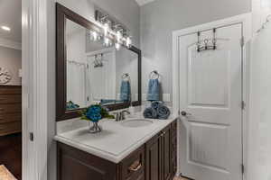 Full bathroom with a shower with curtain, vanity, crown molding, recessed lighting, and light wood-style floors