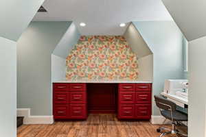 Bathroom with vaulted ceiling, vanity, dark wood-style floors, and recessed lighting