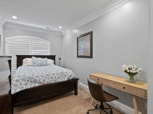 Apartment Carpeted room featuring crown molding, recessed lighting, and an arched window with plantation shutters