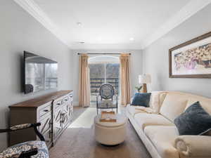 Apartment Light-filled living space featuring a broad window, recessed lighting, crown molding, and neutral wall tones
