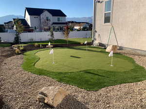 View of property's community featuring a fenced backyard, a mountain view, and a putting green