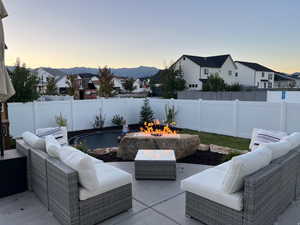 Fenced backyard featuring an outdoor living space with a fire pit, a patio, and a residential view