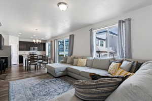 Living room with hanging lights and dark wood-style flooring