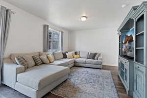 Living room with dark wood-style floors and baseboards