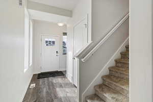 Foyer entrance featuring stairs and wood finished floors