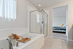 Ensuite bathroom with a bath, a stall shower, and light tile patterned flooring