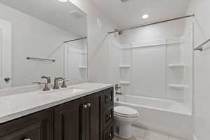 Full bath featuring vanity, bathing tub / shower combination, and light tile patterned flooring