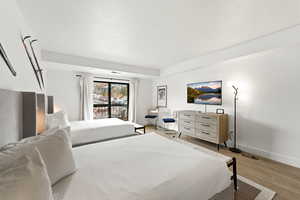Bedroom with light wood-type flooring and a textured ceiling
