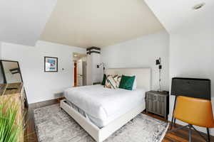 Bedroom featuring dark wood finished floors and baseboards