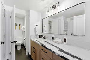 Bathroom featuring vanity, dark tile patterned floors, and a textured ceiling
