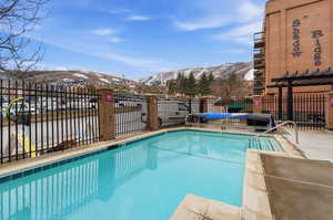 Community pool featuring a patio area, a mountain view, and a pergola