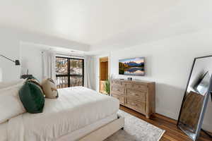 Bedroom featuring access to exterior and dark wood-style floors