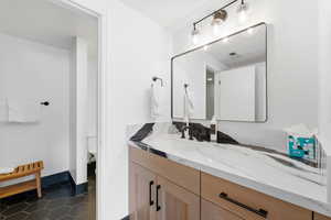 Bathroom featuring vanity and dark tile patterned floors