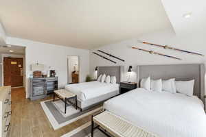 Bedroom featuring light wood-style floors, recessed lighting, and ensuite bath