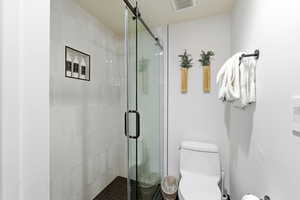 Full bathroom with a stall shower and toilet