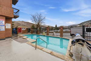 Community pool with a patio and a mountain view