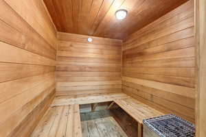 Relaxing sauna / steam room featuring wooden ceiling and wooden walls