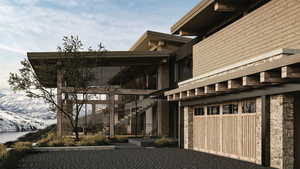 View of side of home featuring a balcony, an attached garage, and driveway