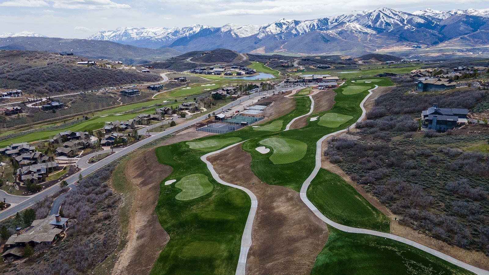 Aerial view of residential area with a golf course and a mountainous background