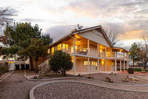 Back of house featuring ceiling fan, stucco and a large deck and porch