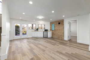 Large family room with kitchenette and brick accent wall