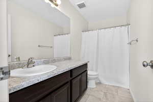 Bathroom with vanity, light tile patterned floors, and shower / bath combination with curtain