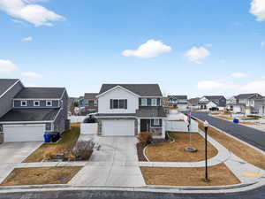 Traditional home with stone siding, a residential view, a garage, concrete driveway, and a gate