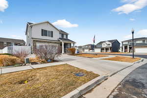 View of front facade with a residential view, concrete driveway, and an attached garage