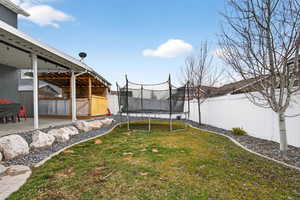 Fenced backyard with a trampoline
