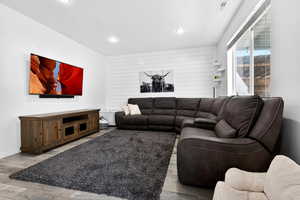 Living area with wood finished floors and recessed lighting