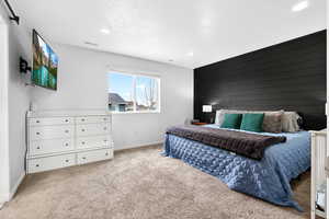Bedroom featuring wood walls, an accent wall, light colored carpet, and recessed lighting