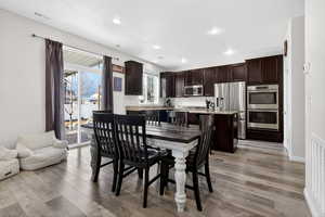 Dining space with light wood-style floors and recessed lighting