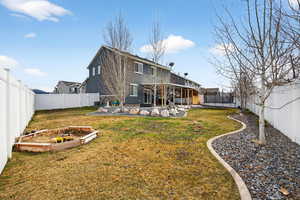 Back of property with a trampoline, a fenced backyard, stucco siding, and a patio