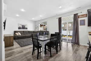Dining area with healthy amount of natural light, light wood-style flooring, recessed lighting, and wood walls