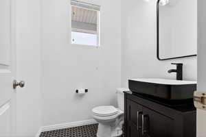 Half bathroom featuring baseboards and vanity