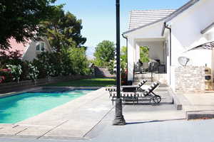 Combined pool / hot tub with a patio area and a fenced backyard